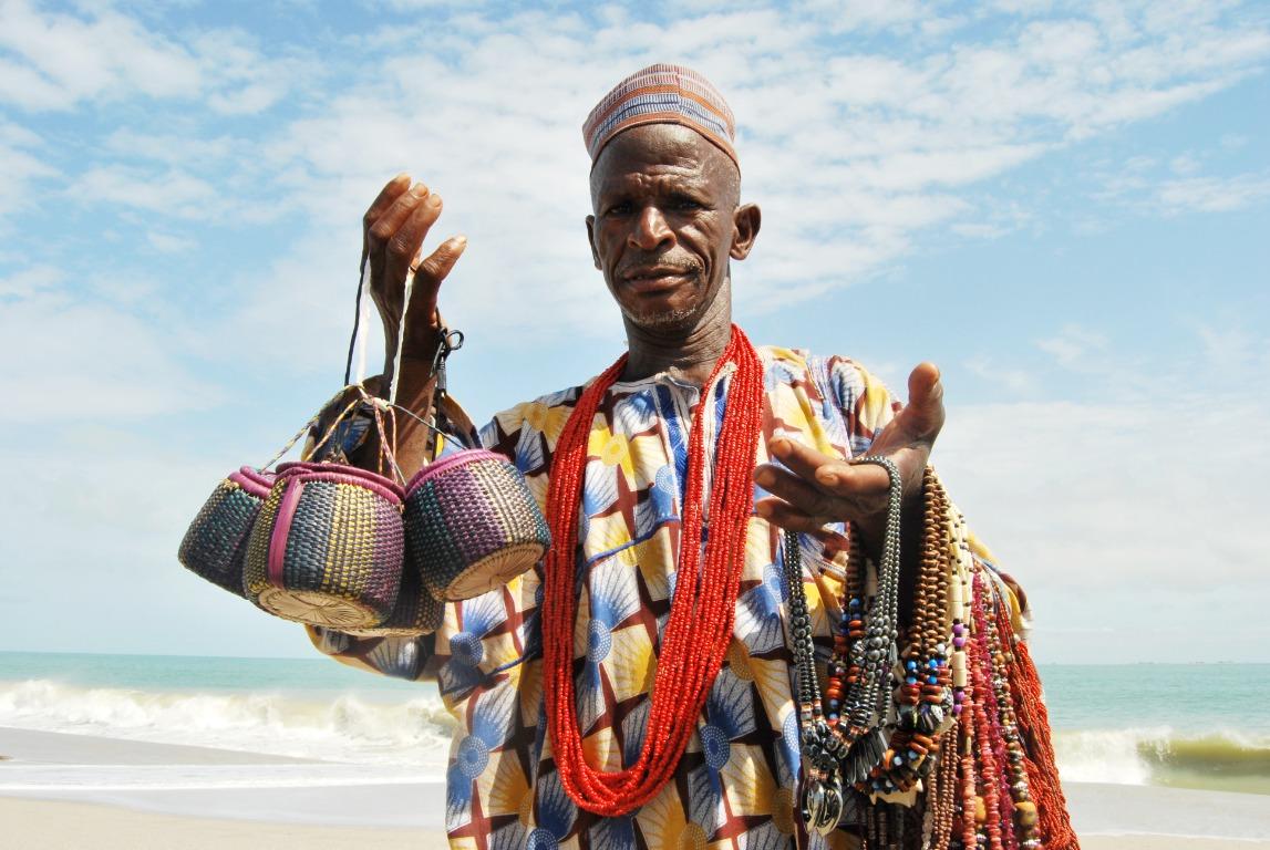 A trader wearing colourful beads and patterned clothing